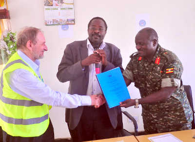 CAA Director of Airports John Kagoro (with file) witnesses hand over of contract between UPDF Chief of Defence Forces Gen. Katumba Wamala and Energo Project boss