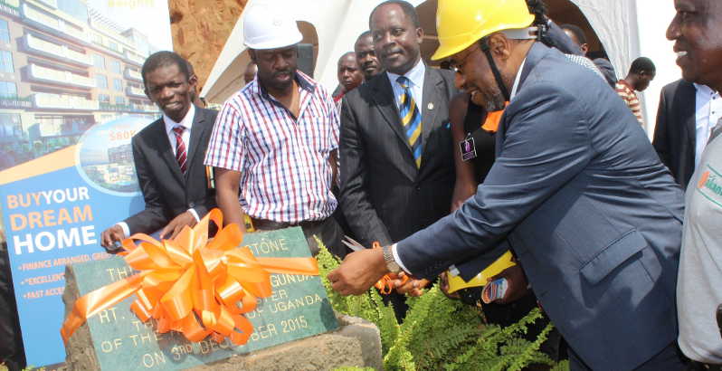 PM Rugunda cuts the tape to symbolize ground breaking for the construction of Jakana Heights condos in Uganda