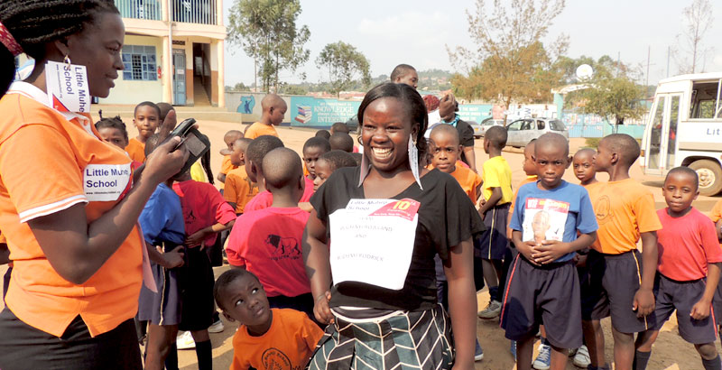 A teacher at Little Muheji in Nansana with her pupils in the background. Teachers are role models and very important in a growing child's life