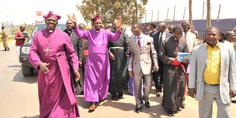 Church of Uganda Arch-Bishop Dr. Stanley Ntagali seen here waving hands while in Mukono. Ntagali along with other bishops were however chased by squatters on CoU land in the same district. Now government says it will help churches secure their land