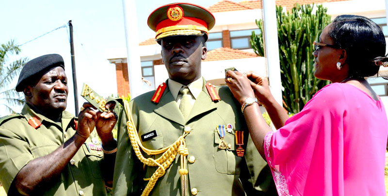 Out-going Chief of Defence Forces (CDF) General Edward Katumba Wamala decorating his successor Maj. Gen. David Muhoozi to the top rank of a four star General