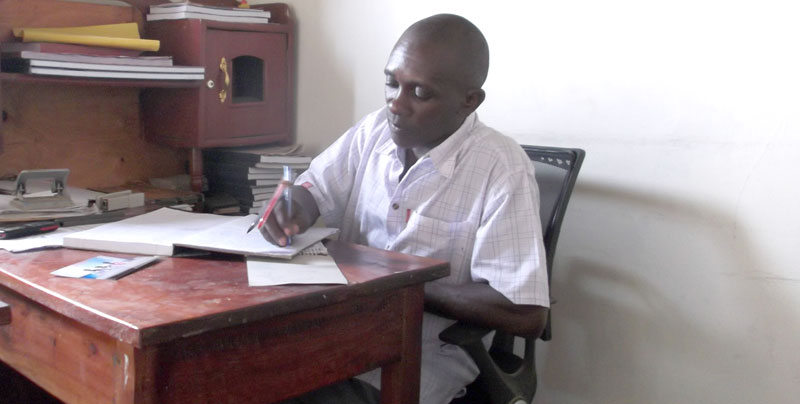 Iyadeli SACCO Manager, John Michael Ekamu, at his desk in his office