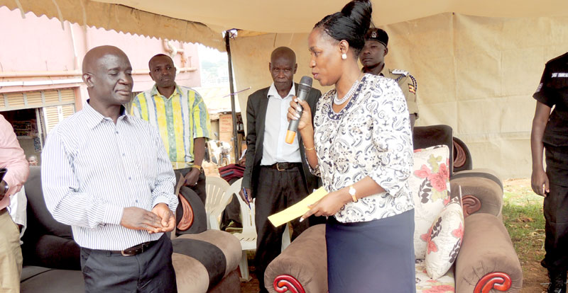 Minister Nakiwala Kiyingi handing over a cheque to Moses Muleke