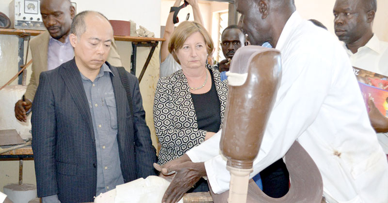 An orthopedic explains to ICC officials Motoo Noguchi (L) and Judge Fenandez (R) how a Swiss limb is made