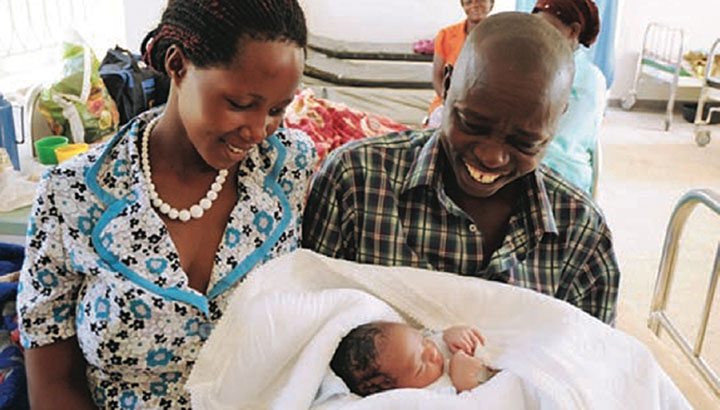 A mum who has just given birth looks at her newly born child with pride