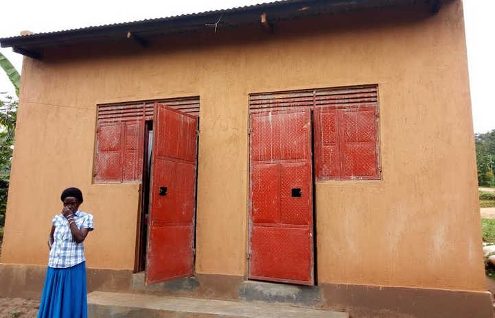 Nagudi standing outside her unimpressive house that was built from the president's money