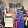 Minister Ssenninde handing over the computers to the school headteachers from 10 schools